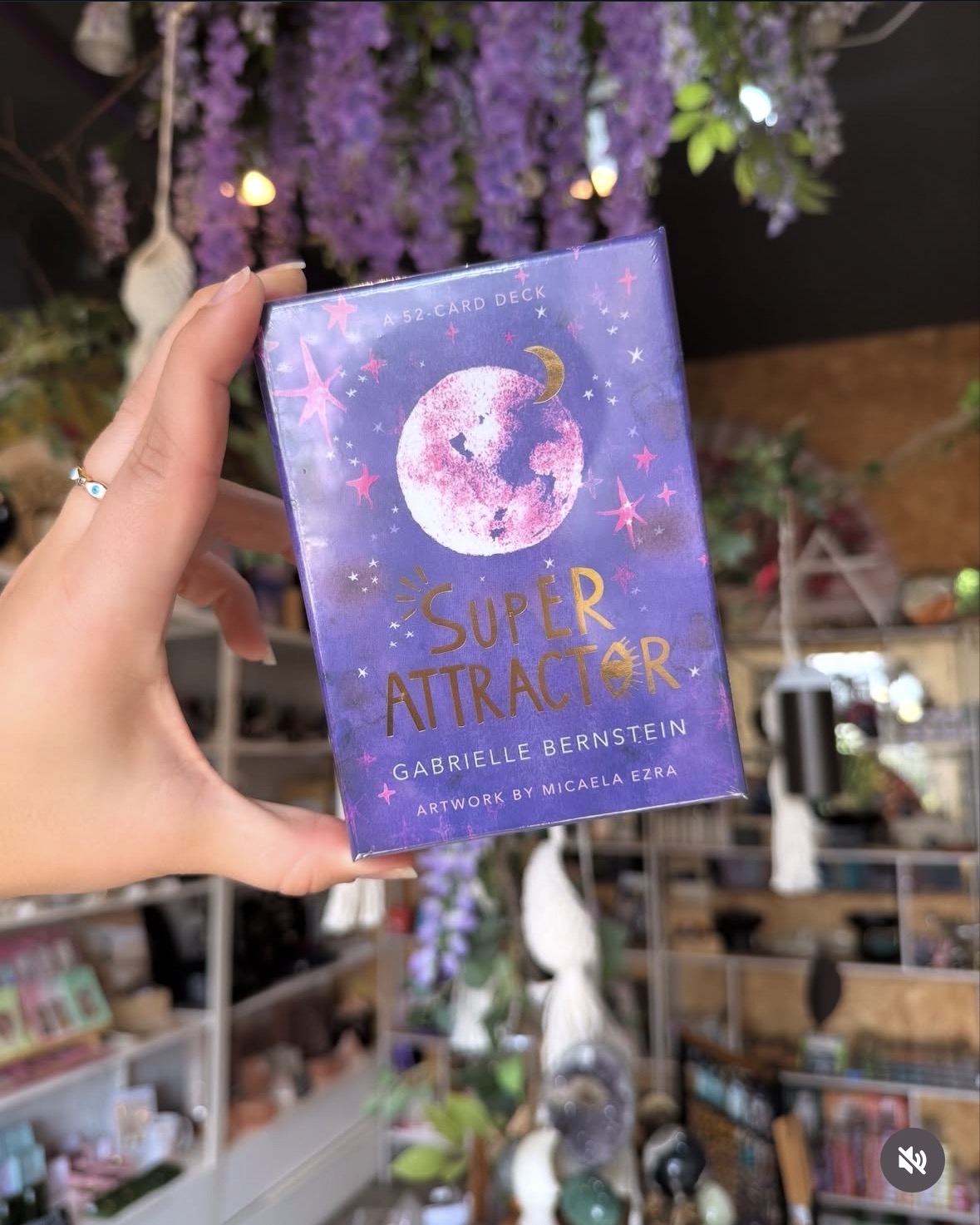 Super Attractor oracle card deck held up in the crystal shop