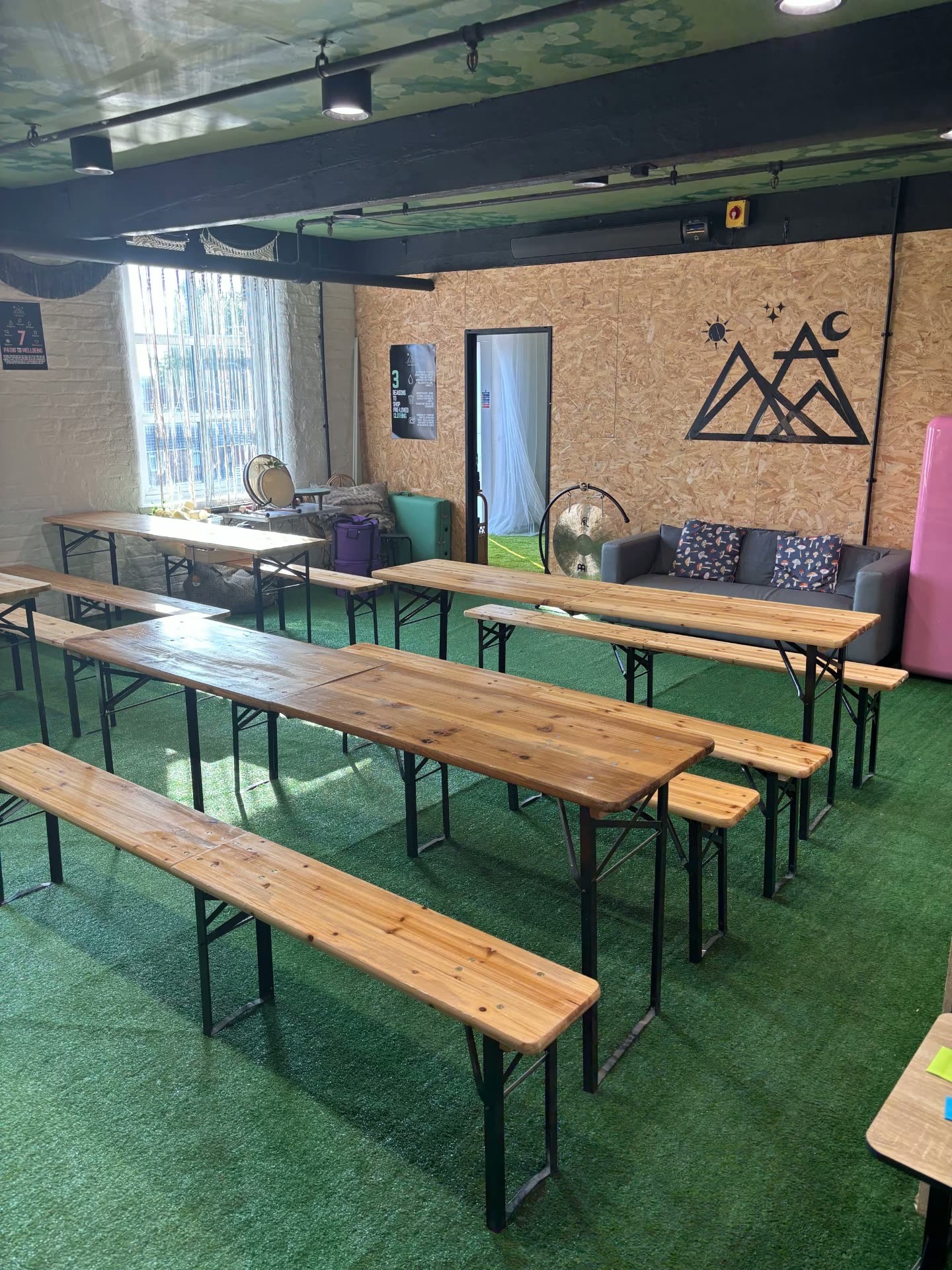The Hive creative space with a green ceiling and long benches
